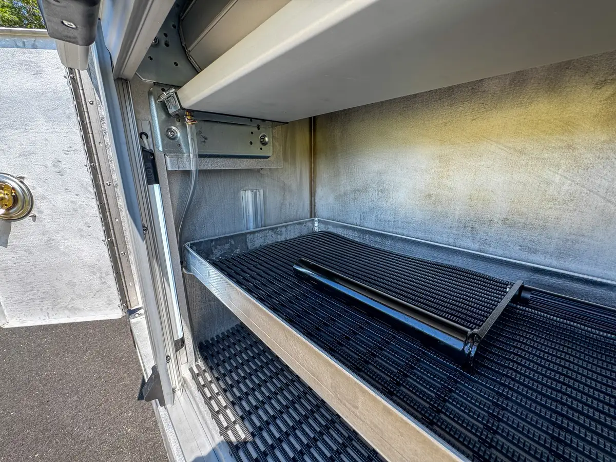 Open pump-service compartment with cylinder and hydraulic components visible.